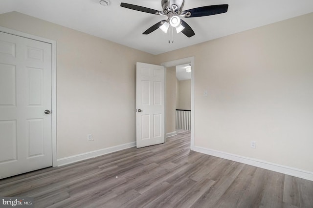 unfurnished bedroom with ceiling fan, baseboards, and wood finished floors