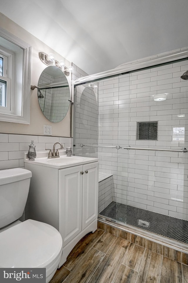 full bath with toilet, a shower stall, wood finished floors, and vanity