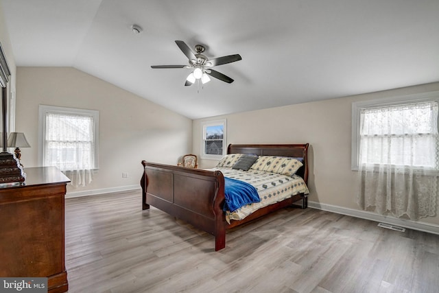 bedroom with baseboards, visible vents, a ceiling fan, wood finished floors, and vaulted ceiling