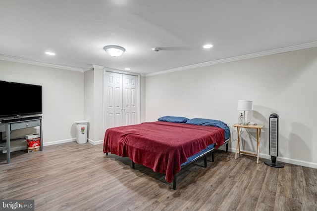 bedroom with recessed lighting, crown molding, baseboards, and wood finished floors