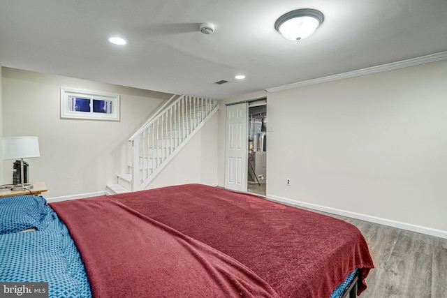 bedroom with recessed lighting, visible vents, ornamental molding, wood finished floors, and baseboards