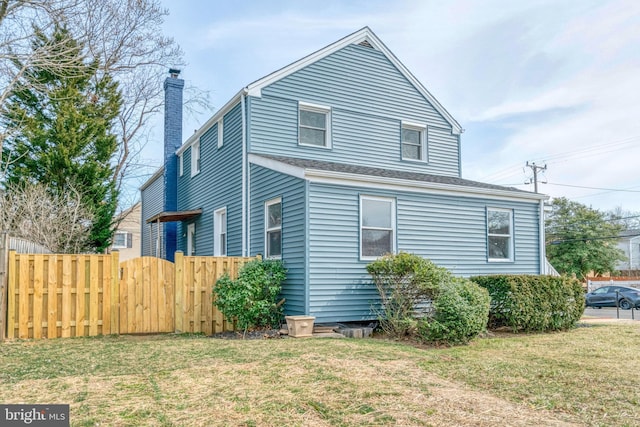 exterior space with a chimney, fence, and a yard