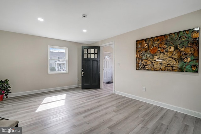 foyer entrance with light wood-style flooring, baseboards, and recessed lighting