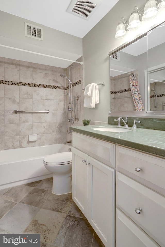 bathroom with toilet, visible vents, and vanity