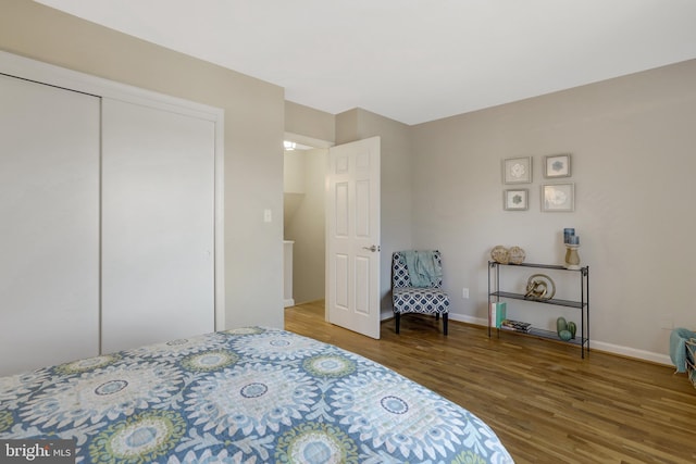 bedroom featuring a closet, baseboards, and wood finished floors