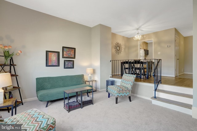 carpeted living room featuring baseboards and an inviting chandelier