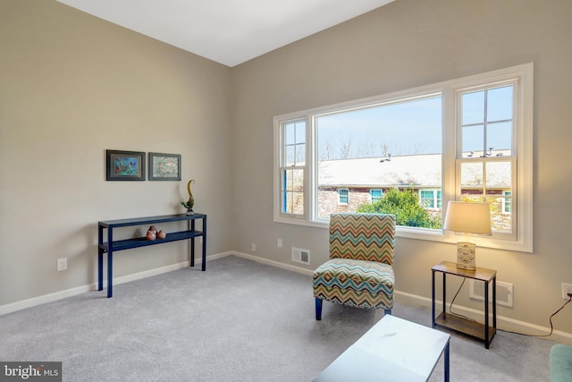 living area with baseboards, carpet, visible vents, and a wealth of natural light