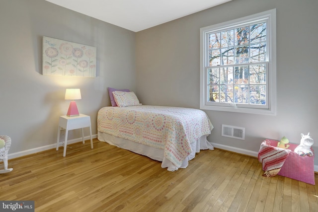 bedroom with light wood finished floors, baseboards, and visible vents