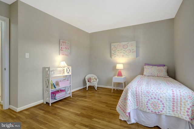 bedroom with baseboards and wood finished floors