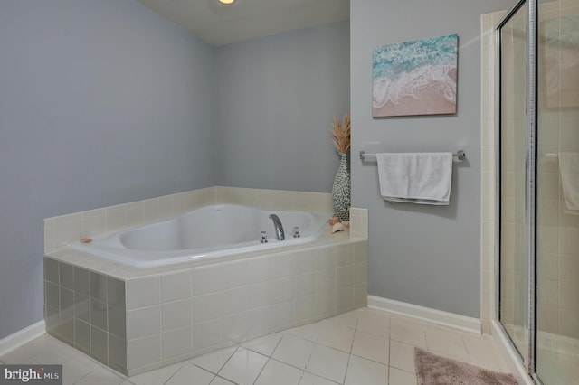 bathroom with a stall shower, tile patterned flooring, baseboards, and a bath