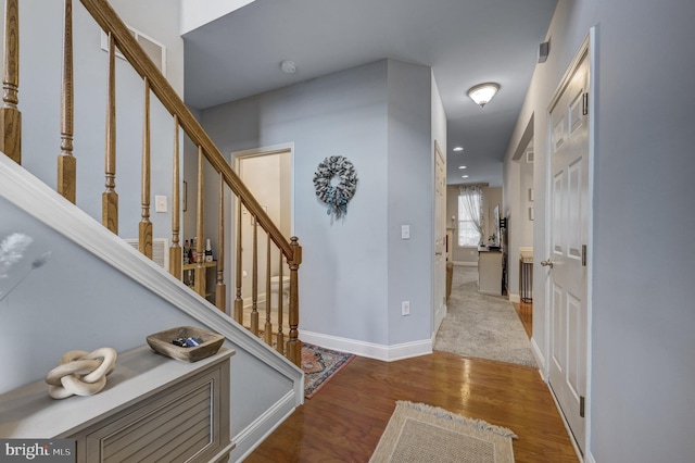 foyer entrance featuring recessed lighting, stairway, baseboards, and wood finished floors