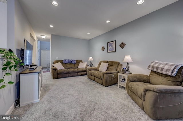 living area with recessed lighting and light carpet