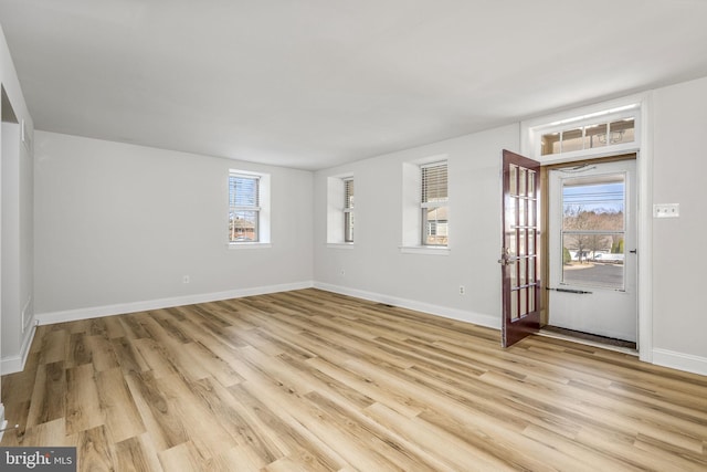 unfurnished room with light wood-style flooring and baseboards