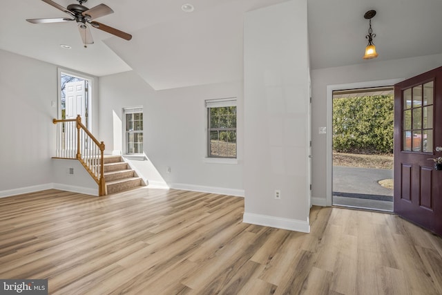 entryway with stairs, vaulted ceiling, baseboards, and light wood finished floors