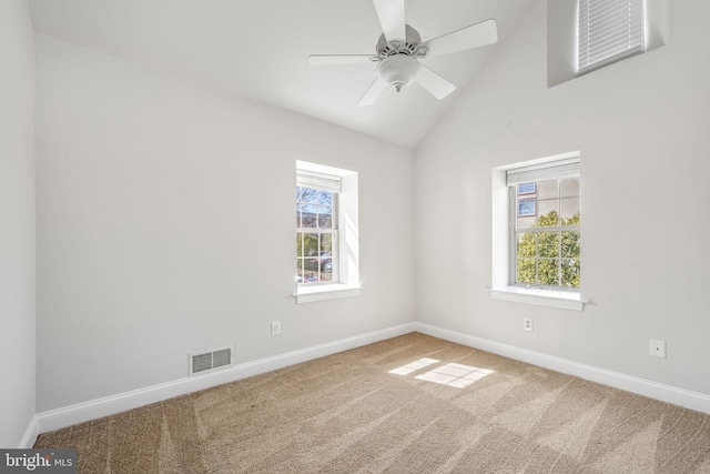 carpeted empty room with visible vents, baseboards, lofted ceiling, and a healthy amount of sunlight