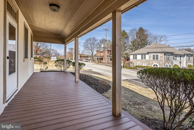 wooden deck with a residential view and covered porch