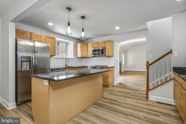 kitchen with tasteful backsplash, visible vents, light wood finished floors, and stainless steel appliances