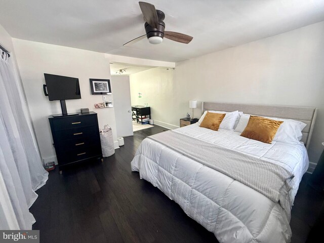 bedroom with dark wood-type flooring, baseboards, and a ceiling fan