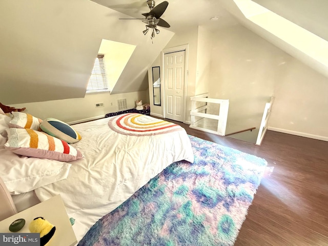 bedroom with visible vents, ceiling fan, vaulted ceiling, wood finished floors, and baseboards