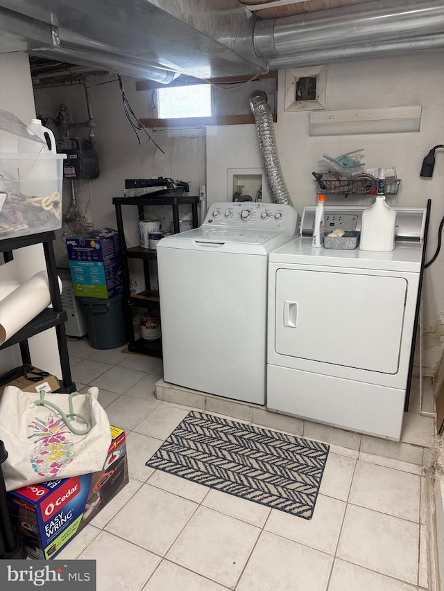 clothes washing area with light tile patterned floors, laundry area, and washer and dryer