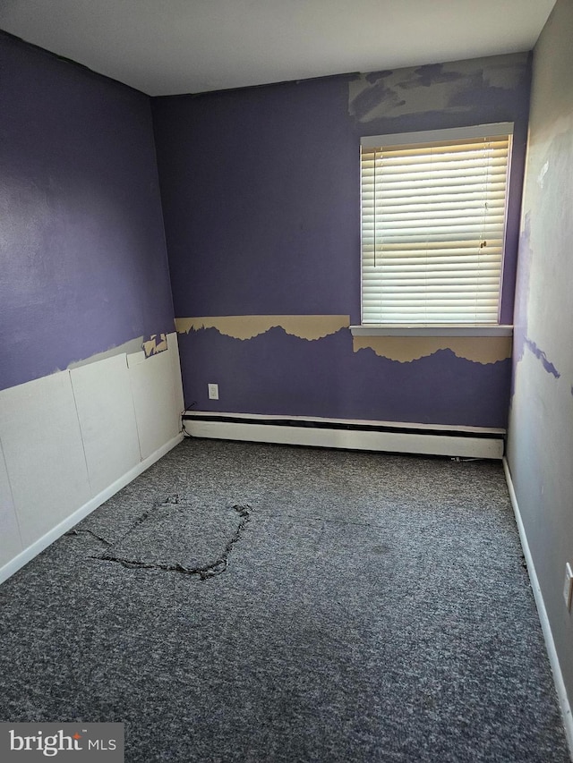 spare room with a baseboard radiator, baseboards, and carpet flooring