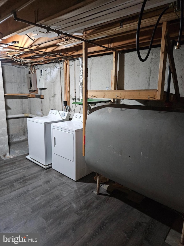 clothes washing area featuring dark wood finished floors, laundry area, independent washer and dryer, and heating fuel