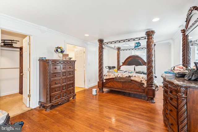 bedroom featuring hardwood / wood-style floors, baseboards, and crown molding