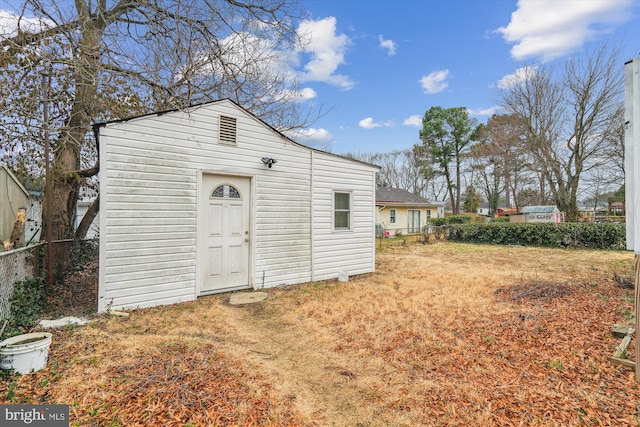 view of outdoor structure featuring fence and an outbuilding