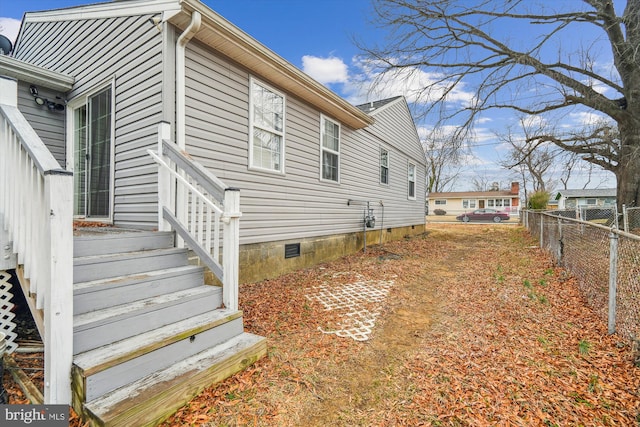 view of property exterior with crawl space and fence