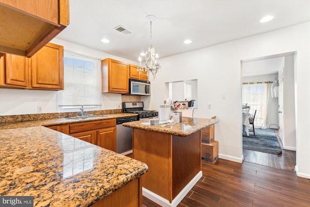 kitchen with a kitchen island, a sink, visible vents, appliances with stainless steel finishes, and dark wood finished floors