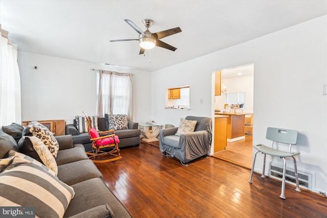 living area with visible vents, ceiling fan, and hardwood / wood-style floors