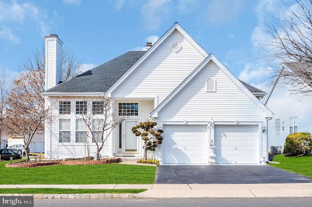 traditional-style house featuring aphalt driveway, roof with shingles, a chimney, central AC unit, and a front lawn