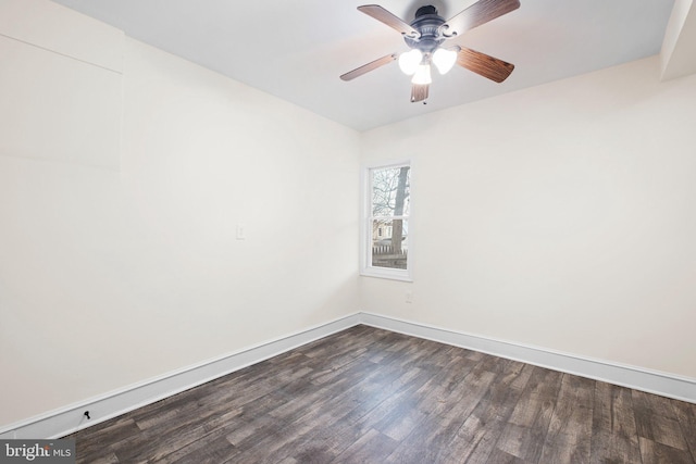 unfurnished room with dark wood-style floors, a ceiling fan, and baseboards