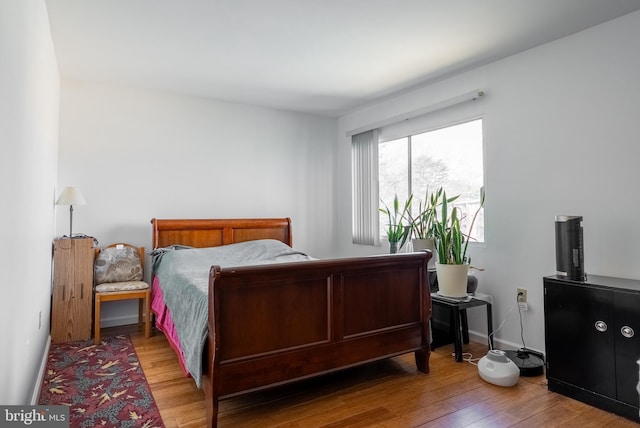 bedroom with baseboards and wood finished floors