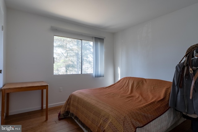 bedroom with baseboards and wood finished floors