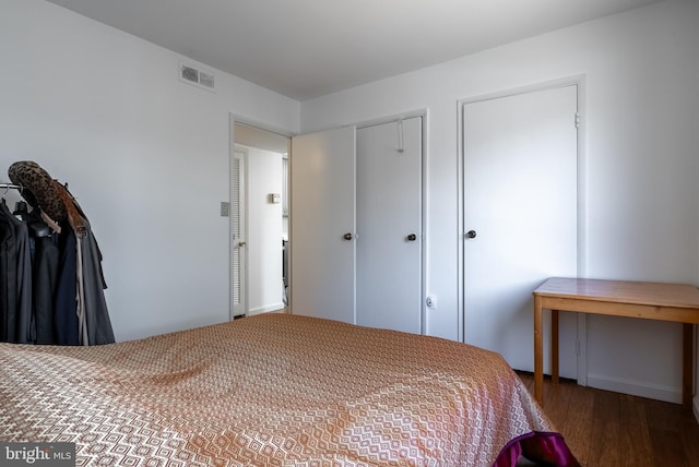 bedroom featuring wood finished floors and visible vents