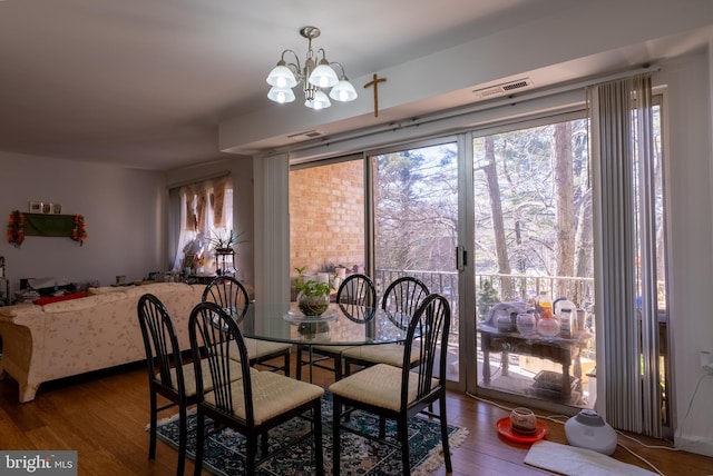 dining room featuring visible vents, a chandelier, and wood finished floors