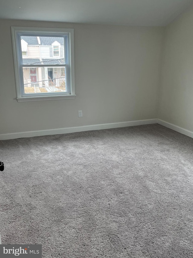 carpeted empty room with baseboards