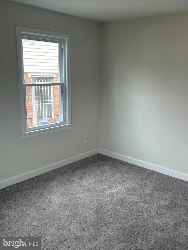 carpeted empty room with baseboards