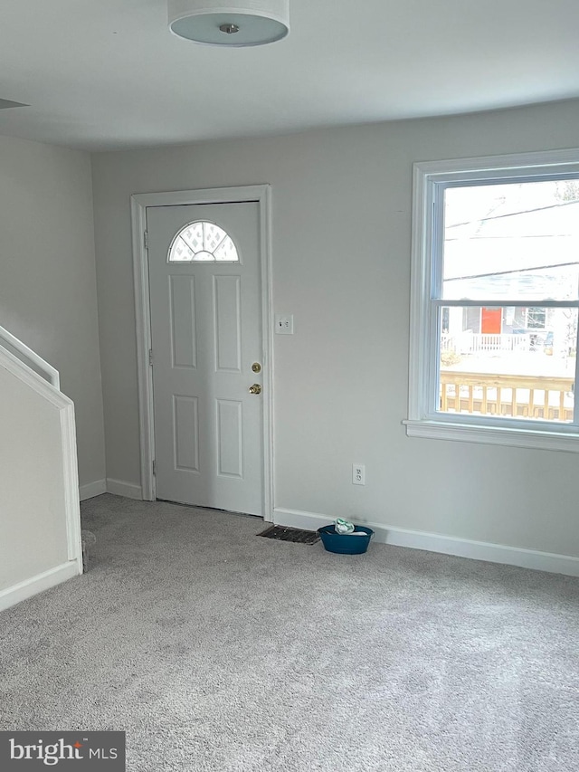 foyer featuring carpet floors and baseboards