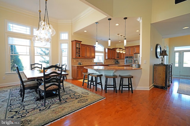 dining room featuring a notable chandelier, crown molding, recessed lighting, wood finished floors, and baseboards