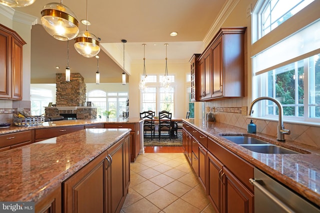 kitchen with a sink, ornamental molding, brown cabinets, and stainless steel dishwasher