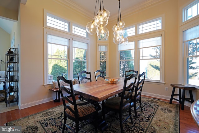 dining space with dark wood-style floors, crown molding, and baseboards