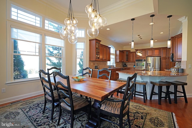 dining room with ornamental molding, dark wood-type flooring, visible vents, and baseboards