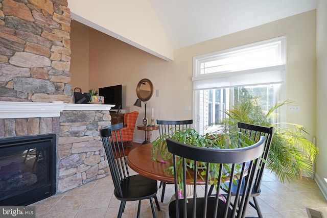 tiled dining room featuring high vaulted ceiling, visible vents, and a fireplace