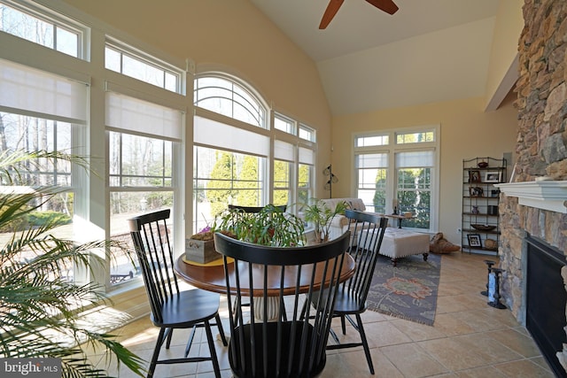 sunroom with lofted ceiling, a fireplace, and a ceiling fan