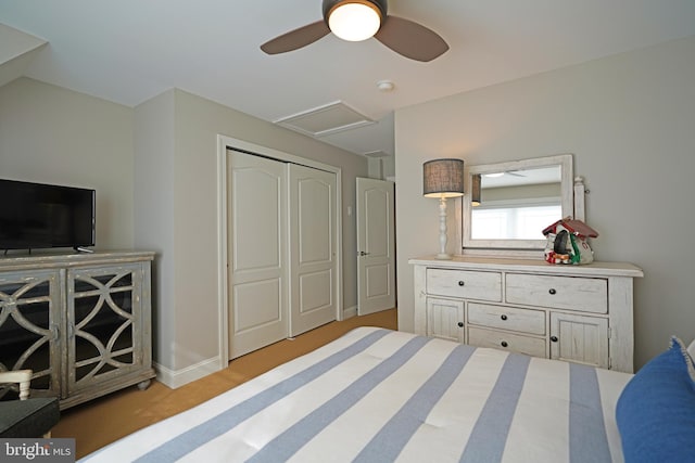 carpeted bedroom with attic access, a closet, ceiling fan, and baseboards