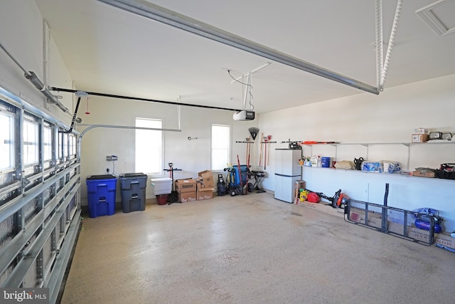 garage with freestanding refrigerator and a garage door opener