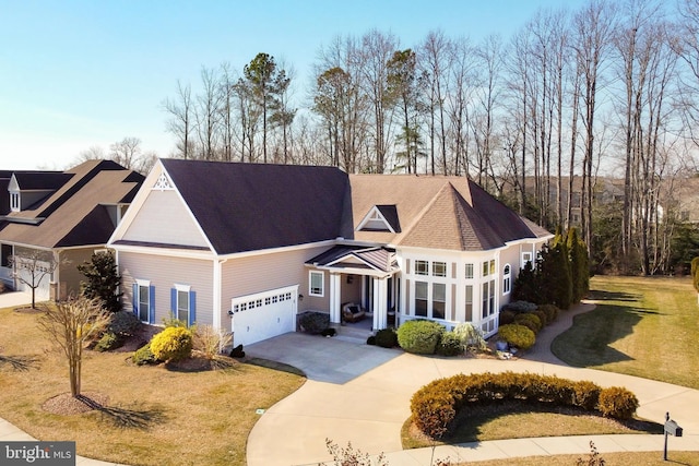 view of front of house with an attached garage, concrete driveway, and a front yard