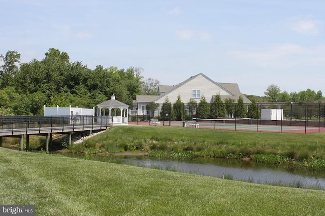 surrounding community featuring a tennis court, fence, a lawn, and a gazebo